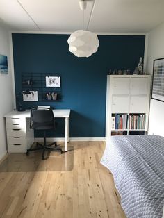 a bedroom with blue walls and wooden floors