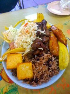 a white plate topped with lots of food on top of a yellow and blue table cloth