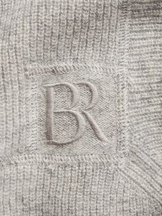 the monogrammed letter b is placed on top of an unbuttoned sweater