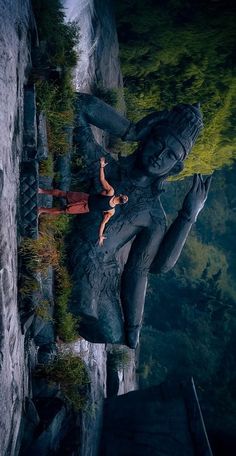 a woman standing next to a statue in the woods