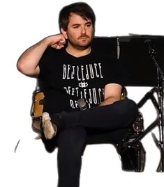 a man sitting on top of a chair next to a microphone