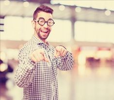 a man wearing glasses standing in an airport