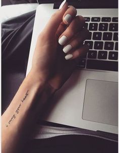 a woman's hand with a small tattoo on her left wrist and the words your heart, tatoologist