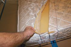 a person is cutting cheese on top of a mattress