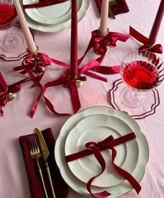 the table is set with white plates and red napkins