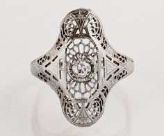 an antique style diamond ring with filigrees