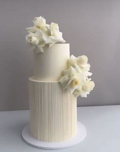 a three tiered cake with white flowers on top