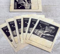 six old - fashioned playing cards sitting on top of a wooden table