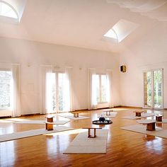 there are many yoga mats in the room and one is on the floor with two windows