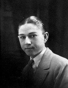 an old black and white photo of a young man in a suit with a serious look on his face