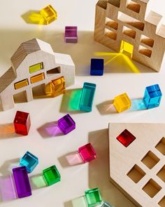 colorful wooden blocks and shapes on a white surface with light coming from the building in the background