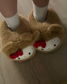 a person wearing hello kitty slippers on top of a wooden floor