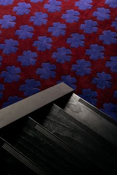 a knife is laying on the floor in front of a red and blue wallpaper