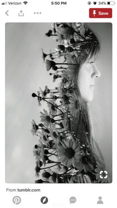 a woman's head with flowers in the middle of her face and behind her is an arrangement of daisies