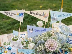 a table topped with lots of blue and white decorations next to a basket filled with flowers