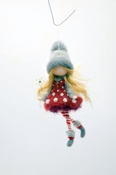 a doll hanging from a string with a hat on it