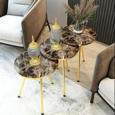 three tables sitting on top of each other in front of a couch and chair with two vases