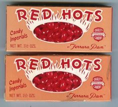 two boxes of red hots candy sitting next to each other