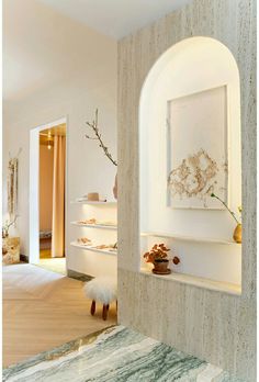 the interior of a home with white walls and marble flooring is decorated in neutral tones