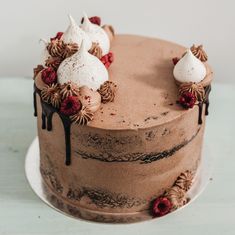 there is a chocolate cake with white frosting and berries on the top, topped with whipped cream