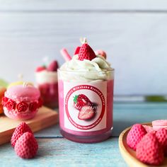 a jar filled with whipped cream and strawberries on top of a wooden tray next to other items