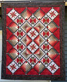 a quilt hanging on the side of a house