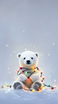 a white polar bear with christmas lights on its chest sitting in the middle of snow