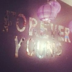 there is a sign on the wall that says power to love with paper lanterns above it