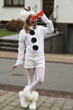 a woman dressed up as a snowman holding a red toothbrush in her mouth