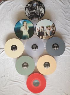 several different colored discs sitting on top of a white sheet with black and white pictures