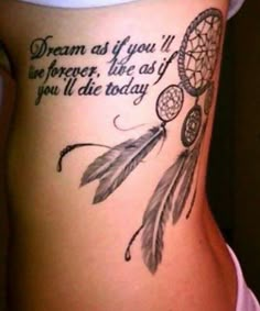 the back of a woman's stomach with a dream catcher tattoo on it