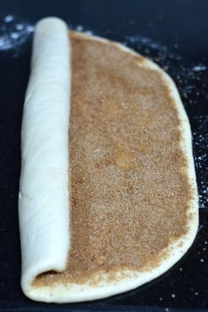 an uncooked bread is sitting on a black surface