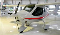 a small white airplane parked in a hanger