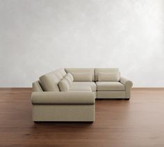 a couch sitting on top of a hard wood floor next to a white wall in an empty room