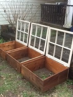 three wooden planters with windows on the side of a house next to a tree