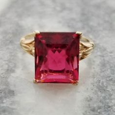 This is a stunning red emerald cut lab created ruby ring. A beautiful ring with rich color. The ring is a size US 6 1/2 The center stones measures about: 7/16 inch (12.6mm) tall 3/8 inch (10.75mm) wide It is marked 10k on the inside of the band It weighs 3.3 grams It is in wearable condition, the stone is a little bit loose in the setting and it has some scratches from being an estate piece of jewelry. Please inspect photos closely before purchasing. This item will be shipped fully insured in th Formal Red Ruby Ring With Rectangular Stone, Formal Emerald Cut Ruby Birthstone Ring, Fine Jewelry Red Rings With Rectangular Stone, Classic Square-cut Ruby Ring, Classic Red Ruby Ring With Square Cut, Red Emerald Cut Solitaire Ruby Ring, Red Emerald-cut Solitaire Ruby Ring, Emerald Cut Solitaire Ruby Ring In Red, Red Square Cut Ruby Ring Gift