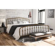 a bedroom with white brick walls and hardwood floors, including a bed frame that has black iron designs on it