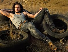 a man laying on top of two old tires