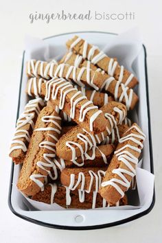 gingerbread biscuits with white icing in a black and white box on a table