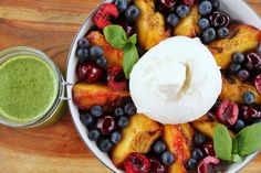 a bowl filled with fruit and ice cream on top of a wooden cutting board