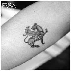 a black and white photo of a small tattoo on the arm, with an animal in the middle