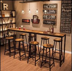 a bar with four stools in front of it and several signs on the wall