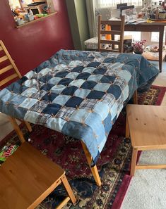 a bed sitting on top of a rug next to a wooden table and chair in a room