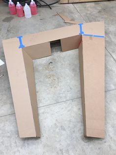 an open cardboard box sitting on the ground with blue tape around it's edges