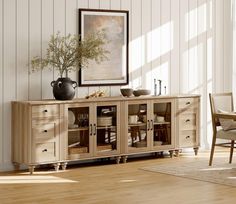 a room with a table, chair and vase on top of the sideboard in it