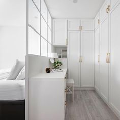 a bedroom with white walls and flooring next to a bed in a room that has wooden floors