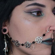 a woman with black hair and piercings on her nose