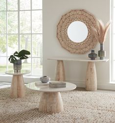 a living room with two tables and a round mirror