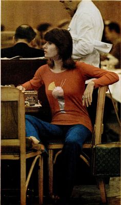 a woman sitting in a chair next to a table