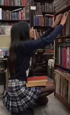 a girl reaching for books in a library